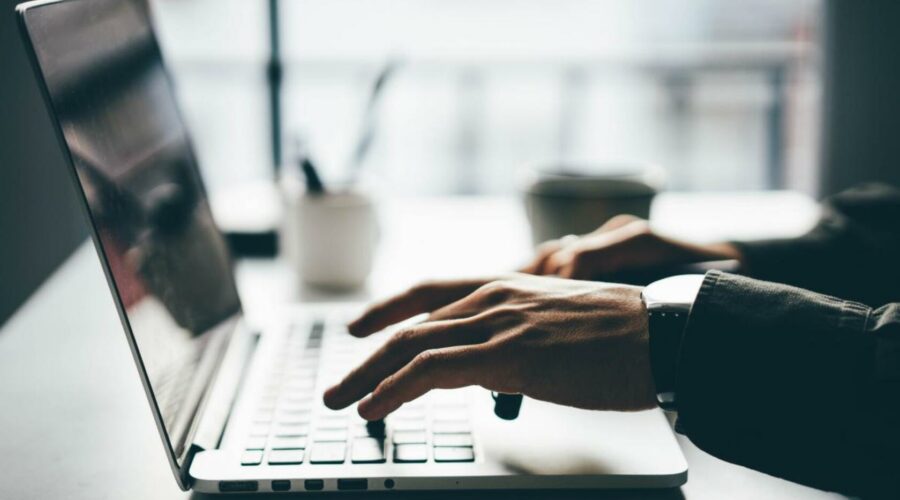 una-persona-trabajando-con-el-teclado-del-ordenador-en-la-oficina (1)